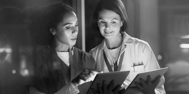 Two physicians reviewing records together on a tablet